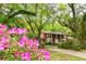 Beautiful two-story brick home with a circular driveway surrounded by lush azalea bushes and a manicured lawn at 11159 Cindy Dr, Brooksville, FL 34601