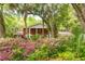 Charming brick home with mature trees and colorful flowering bushes in the front yard at 11159 Cindy Dr, Brooksville, FL 34601