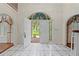 Inviting foyer with arched doorway, white tile flooring, and a glimpse of the outdoors through the open door at 11159 Cindy Dr, Brooksville, FL 34601