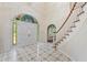 Elegant foyer features stained glass over the door, patterned tile floor, and a curved staircase at 11159 Cindy Dr, Brooksville, FL 34601