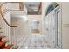 Grand foyer with a winding staircase, tiled floors, and a decorative peacock-themed window above the entrance at 11159 Cindy Dr, Brooksville, FL 34601