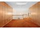 Hallway with wood paneling, brown carpet, and stairs leading to another level with a chandelier at 11159 Cindy Dr, Brooksville, FL 34601