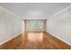Spacious living room features hardwood floors, classic wallpaper, and a bay window at 11159 Cindy Dr, Brooksville, FL 34601
