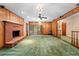 Spacious living room with wood paneling, a fireplace, and access to the backyard at 11159 Cindy Dr, Brooksville, FL 34601