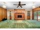 Bright living room featuring wood paneling, a brick fireplace, and views of the pool at 11159 Cindy Dr, Brooksville, FL 34601