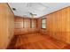Living room with wood paneling, built-in bookcase, ceiling fan, and carpeting at 11159 Cindy Dr, Brooksville, FL 34601