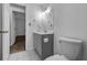 Bathroom with modern gray vanity, toilet, and updated lighting at 1116 Jadewood Ave, Clearwater, FL 33759