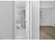 Well-lit bathroom featuring tiled walls, a shower-tub combination, and access to another bedroom at 1116 Jadewood Ave, Clearwater, FL 33759