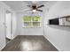 Dining area featuring gray laminate flooring, a ceiling fan, and a window with natural light at 1116 Jadewood Ave, Clearwater, FL 33759