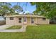 Charming single-story home with a welcoming porch, landscaped yard, and brick facade at 1116 Jadewood Ave, Clearwater, FL 33759