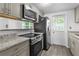Bright kitchen with stainless steel appliances, granite countertops and gray cabinets at 1116 Jadewood Ave, Clearwater, FL 33759