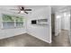 Living area featuring gray floors, a ceiling fan, and a view of the kitchen at 1116 Jadewood Ave, Clearwater, FL 33759