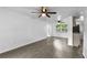 Bright living room featuring modern gray flooring, ceiling fans, and an open layout flowing into the kitchen at 1116 Jadewood Ave, Clearwater, FL 33759