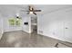 Bright living room featuring modern gray flooring, ceiling fans, with kitchen view and lots of light at 1116 Jadewood Ave, Clearwater, FL 33759
