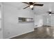 Open-concept living space with gray floors, a ceiling fan, and a view of the kitchen at 1116 Jadewood Ave, Clearwater, FL 33759