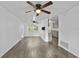 Living room with gray wood-look floors, ceiling fan, and view of the kitchen with breakfast bar at 1116 Jadewood Ave, Clearwater, FL 33759
