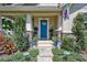 Inviting front porch with a blue door, manicured landscaping, and decorative lighting at 1119 Highland S St, St Petersburg, FL 33701
