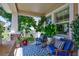 Relaxing front porch with rocking chairs, a blue patterned rug, and lush potted plants at 1119 Highland S St, St Petersburg, FL 33701