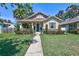 Charming bungalow with a blue front door and well-manicured lawn and landscaped garden at 1119 Highland S St, St Petersburg, FL 33701