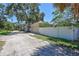 Exterior view of a one-car garage with white privacy fence and natural landscaping at 1119 Highland S St, St Petersburg, FL 33701