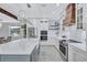 Open concept kitchen with stainless appliances, island with breakfast bar, and bright white cabinets at 1119 Highland S St, St Petersburg, FL 33701