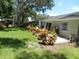 Serene backyard featuring a patio, mature trees, and colorful landscaping at 1212 Rosewood St, Largo, FL 33770