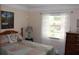 Comfortable bedroom featuring a patchwork quilt, dresser, and window with lace curtains at 1212 Rosewood St, Largo, FL 33770