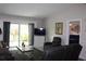 Living room showcases a tv, reclining chair, and sliding glass doors that lead to the backyard at 1212 Rosewood St, Largo, FL 33770