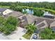 Aerial view of home showing its roofline, driveway, landscaping, and serene lake in the background at 13821 Moonstone Canyon Dr, Riverview, FL 33579
