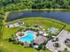 Aerial view of community pool, playground, basketball court, and lake surrounded by lush greenery at 13821 Moonstone Canyon Dr, Riverview, FL 33579