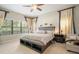 Serene bedroom featuring a plush bed, neutral tones, and large windows for ample natural light at 13821 Moonstone Canyon Dr, Riverview, FL 33579