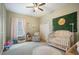 Well-lit Bedroom featuring a crib, rocker, shelves, and stylish decorations at 13821 Moonstone Canyon Dr, Riverview, FL 33579