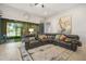 Cozy living room with a large sectional sofa, decorative rug, and views of the screened patio at 13821 Moonstone Canyon Dr, Riverview, FL 33579