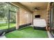 Relaxing screened patio featuring faux grass, a ceiling fan, and views of a lush green space at 13821 Moonstone Canyon Dr, Riverview, FL 33579