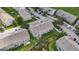 Aerial view of the property highlights the townhomes and community with ample parking and green spaces at 13905 Abbey Ln, Largo, FL 33771