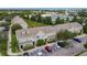 Aerial view of townhomes with parking spaces surrounded by lush greenery and a small stream at 13905 Abbey Ln, Largo, FL 33771