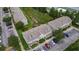 Aerial view showcases the townhome complex with a creek, landscaping, and parking at 13905 Abbey Ln, Largo, FL 33771