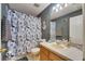 Nautical-themed bathroom with anchor decor, patterned shower curtain, and vanity at 13905 Abbey Ln, Largo, FL 33771