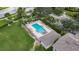 A drone shot of a community pool with ample lounge seating, tropical landscaping, and convenient parking at 13905 Abbey Ln, Largo, FL 33771
