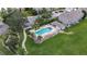 Aerial perspective of a community pool with lounge chairs, mature palm trees, and a well-manicured green lawn at 13905 Abbey Ln, Largo, FL 33771