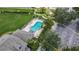 Aerial view of a community pool with lounge chairs surrounded by lush greenery and a well maintained lawn at 13905 Abbey Ln, Largo, FL 33771