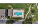 Top-down shot of community pool with lounge chairs for relaxation, lush landscaping, and nearby parking at 13905 Abbey Ln, Largo, FL 33771