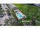 Overhead shot of a community pool, featuring lounge chairs, tropical plants, and a paved walkway at 13905 Abbey Ln, Largo, FL 33771