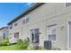 A view of the rear exterior showing the patio, lawn, and AC units at 13905 Abbey Ln, Largo, FL 33771