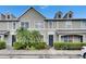 Charming townhome featuring manicured landscaping, a well-lit walkway, and neutral exterior paint at 13905 Abbey Ln, Largo, FL 33771