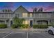 Charming townhome featuring manicured landscaping, a well-lit walkway, and neutral exterior paint at 13905 Abbey Ln, Largo, FL 33771