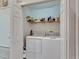 Functional laundry room featuring a washer and dryer with built-in shelving for storage at 13905 Abbey Ln, Largo, FL 33771