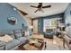 Bright living room with comfortable seating, blue walls, and an open floor plan at 13905 Abbey Ln, Largo, FL 33771