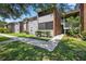 Charming condo with mature trees, gray siding, brick accents, and inviting walkway at 1400 Gandy N Blvd # 809, St Petersburg, FL 33702