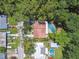 Aerial view of a quaint house and neighborhood nestled amongst mature Florida trees at 1402 E Mimosa Dr, Plant City, FL 33563